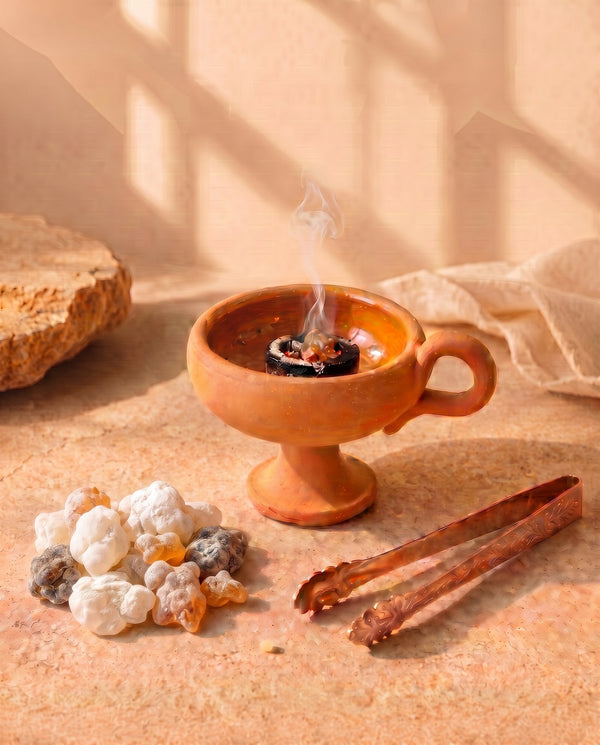 The First Flame ritual kit — resin, burner, tongs and coal laid out on stone